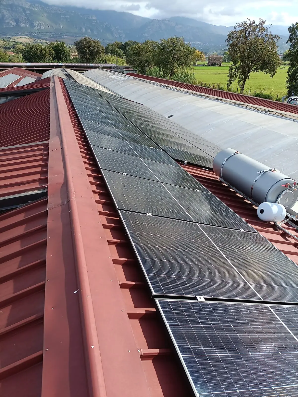Pannelli fotovoltaici sul tetto della stalla di Masseria Cilentana, con le montagne sullo sfondo
